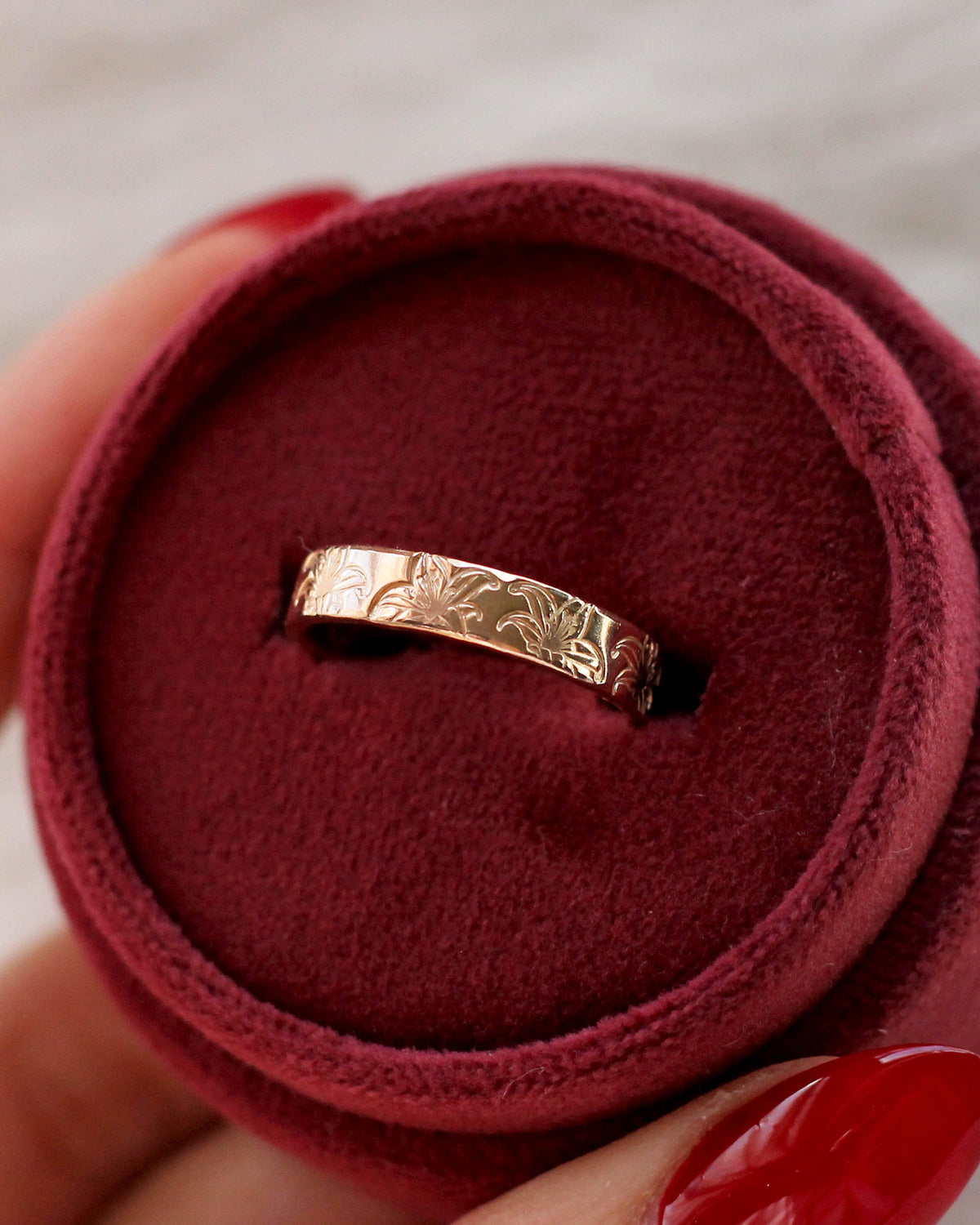 A gold filled band ring with hand stamped lily flowers.